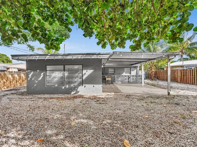 a front view of house with yard and trees in the background