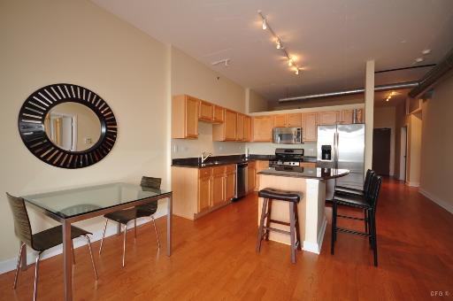 1305 South Michigan Avenue, Unit 1702 Chicago, IL 60605 - Photo 2 of 13 a kitchen with a dining table chairs and a refrigerator