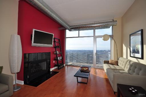 1305 South Michigan Avenue, Unit 1702 Chicago, IL 60605 - Photo 4 of 13 a living room with furniture a flat screen tv and a floor to ceiling window
