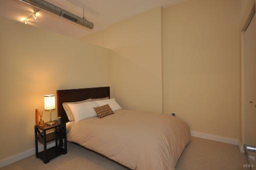 1305 South Michigan Avenue, Unit 1702 Chicago, IL 60605 - Photo 5 of 13 a bedroom with a bed and a night stand