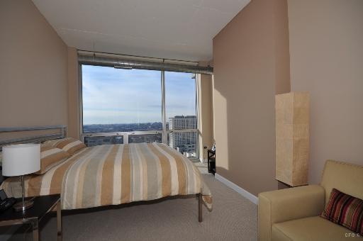 1305 South Michigan Avenue, Unit 1702 Chicago, IL 60605 - Photo 7 of 13 a bed sitting in a bedroom next to a window