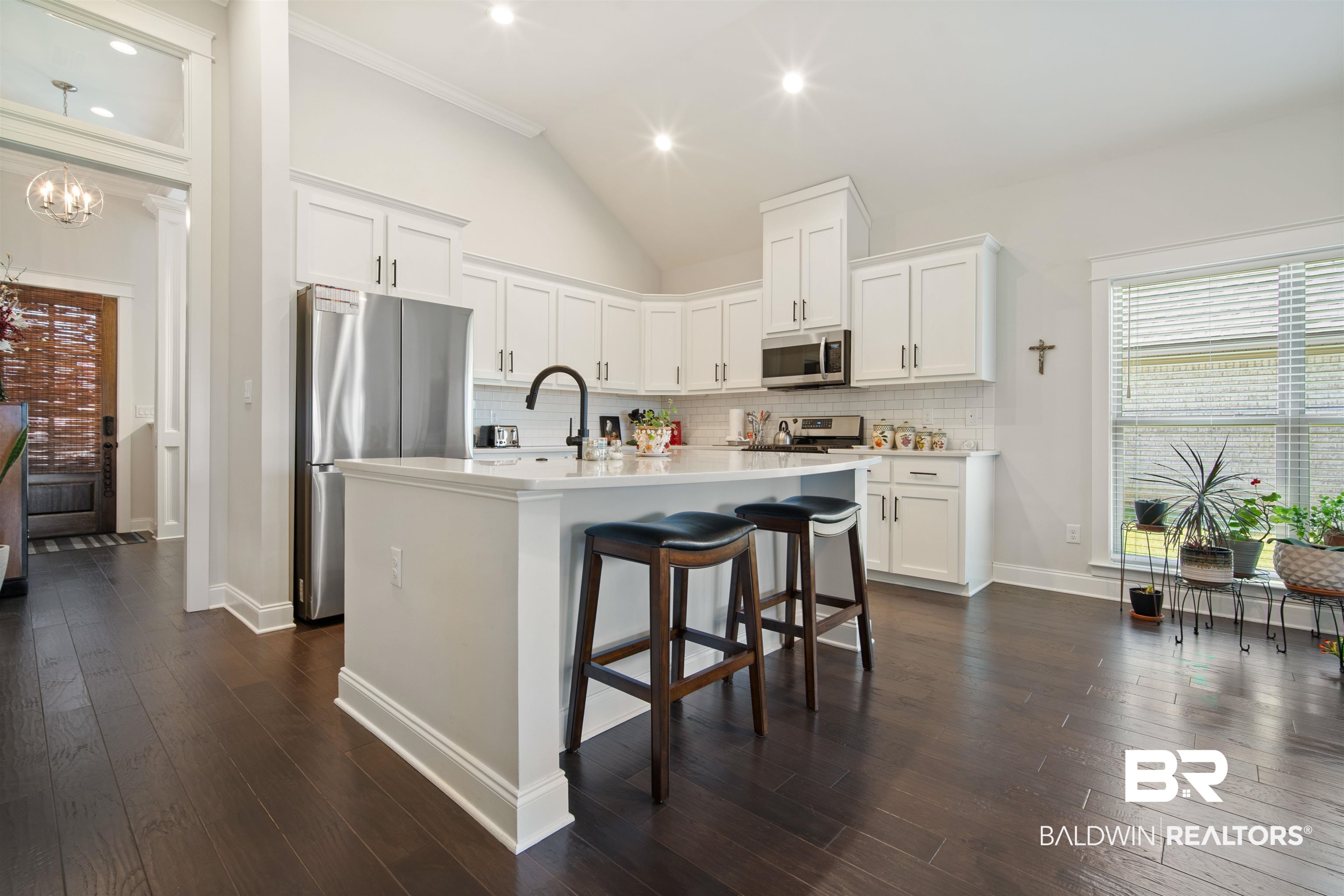 969 Charleston Loop Fairhope, AL 36532 - Photo 9 of 30 Kitchen with backsplash, stainless steel appliances, a kitchen island with sink, white cabinets, and dark hardwood / wood-style flooring