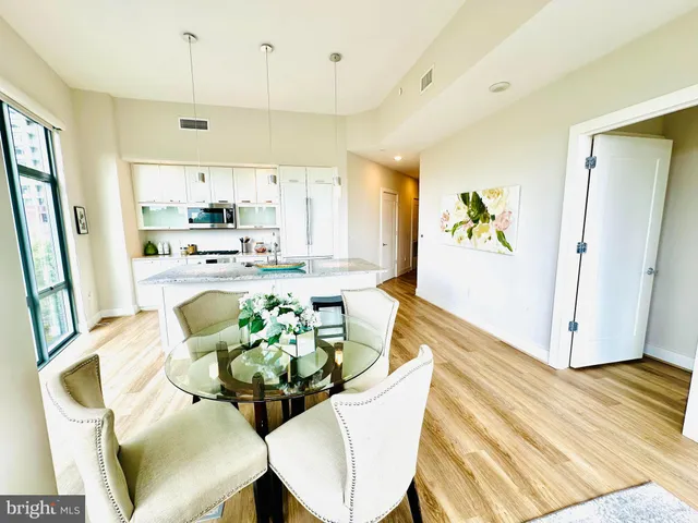 a kitchen with a table chairs and wooden floor
