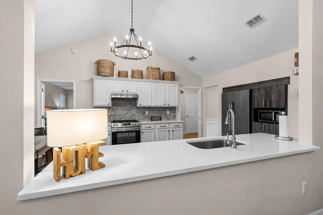 a kitchen with stainless steel appliances granite countertop a kitchen island hardwood floor sink and stove