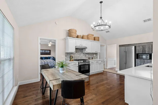 a kitchen with stainless steel appliances granite countertop a lot of counter space and wooden floors