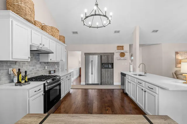 a kitchen with white cabinets and appliances