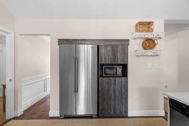 a kitchen with stainless steel appliances granite countertop wooden floors and white cabinets