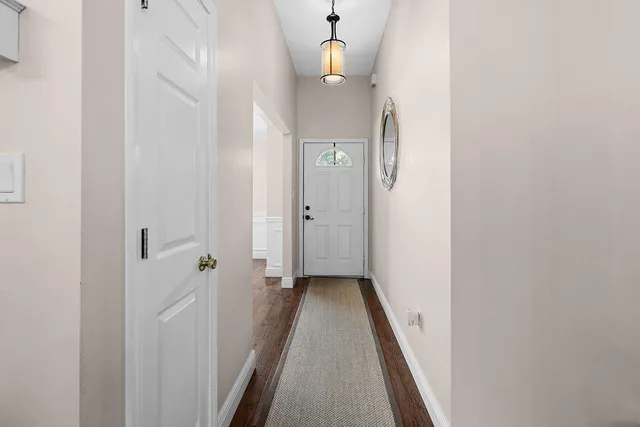 a view of a hallway with wooden floor and staircase