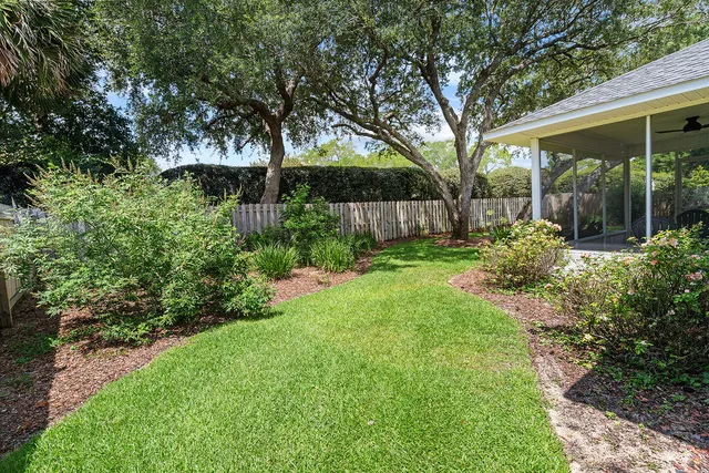a front view of a house with a garden and trees