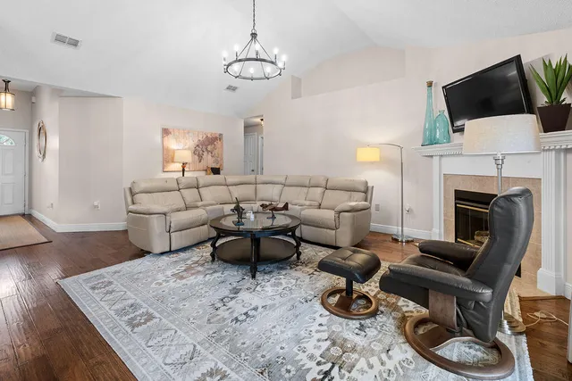 a living room with furniture a flat screen tv and a fireplace