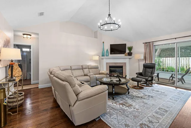 a living room with furniture a flat screen tv and a fireplace