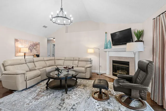 a living room with furniture a fireplace and a flat screen tv