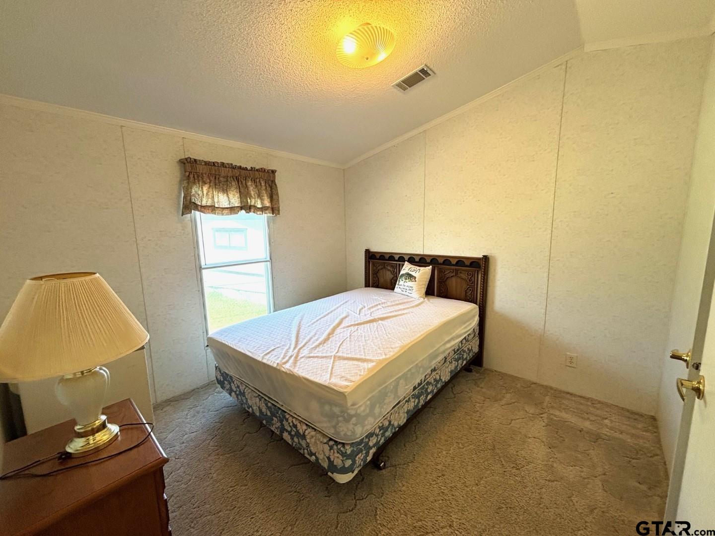 21893 Boles Road Frankston, TX 75763 - Photo 17 of 33 a bed sitting in a bedroom next to a window