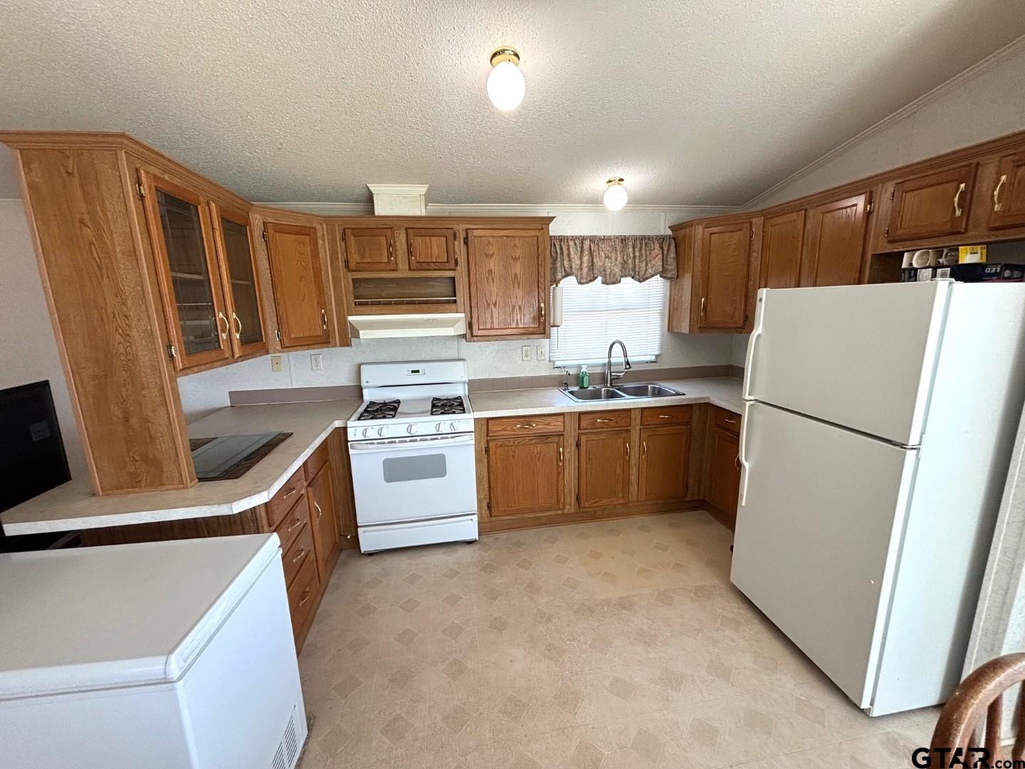 21893 Boles Road Frankston, TX 75763 - Photo 4 of 33 a kitchen with a refrigerator a stove top oven a sink and dishwasher