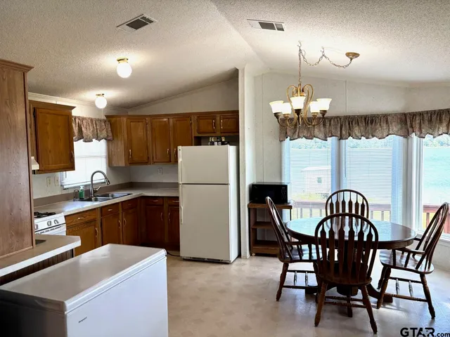 a kitchen with refrigerator a table and chairs