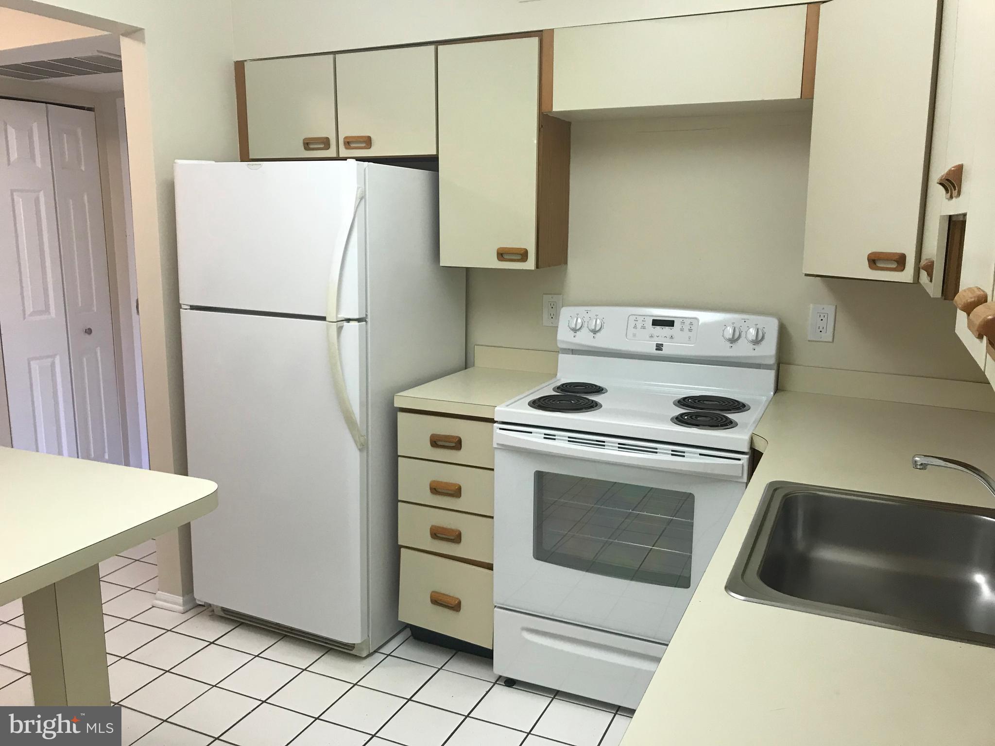 2901 Fallstaff Road, Unit 505 Baltimore, MD 21209 - Photo 6 of 15 a white refrigerator freezer and a stove sitting inside of a kitchen
