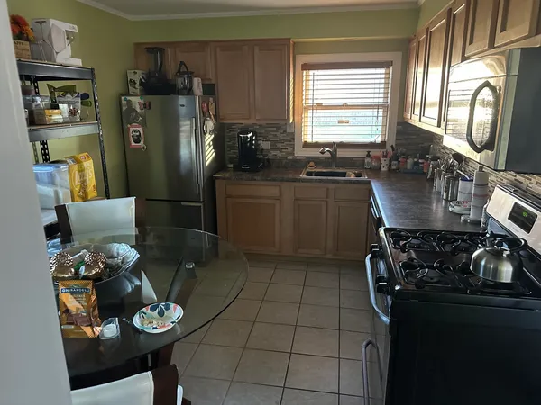 a kitchen with stainless steel appliances granite countertop a sink refrigerator stove and microwave
