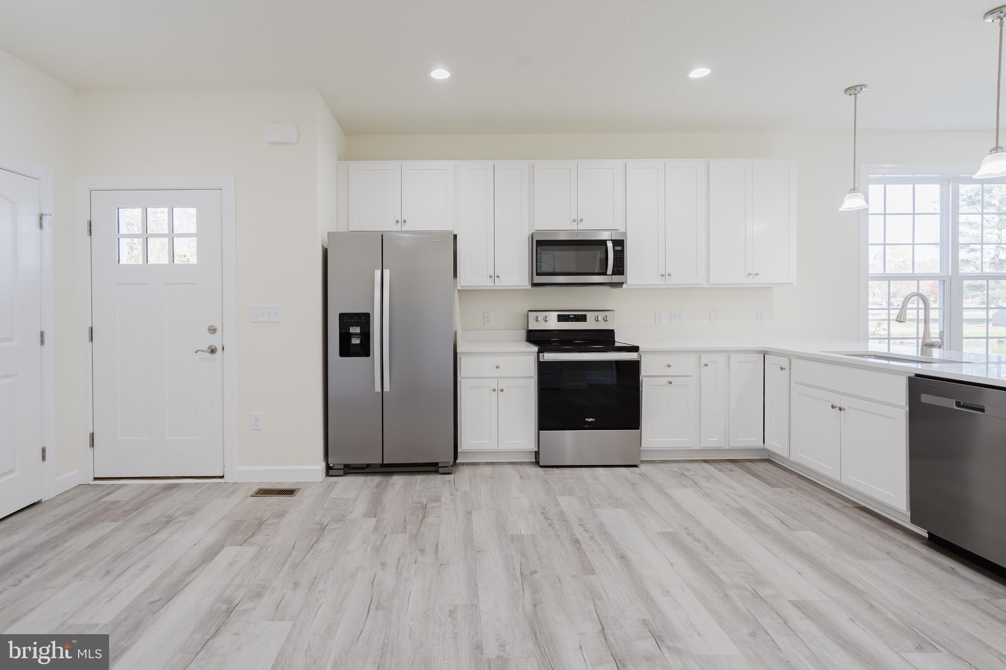 51 Mapledale Road Dover, DE 19904 - Photo 15 of 53 a kitchen with stainless steel appliances granite countertop a refrigerator stove a sink and white cabinets with wooden floor
