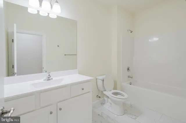 a bathroom with a sink a toilet and a large mirror