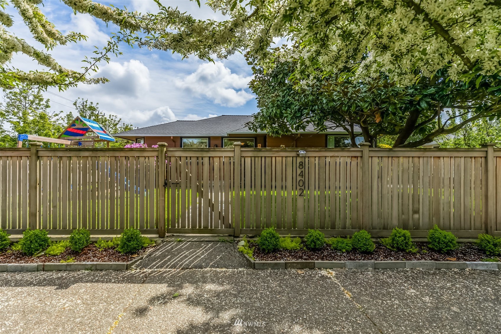 8402 13th Avenue Southwest Seattle, WA 98106 - Photo 2 of 40 a view of a backyard with plants and a large tree