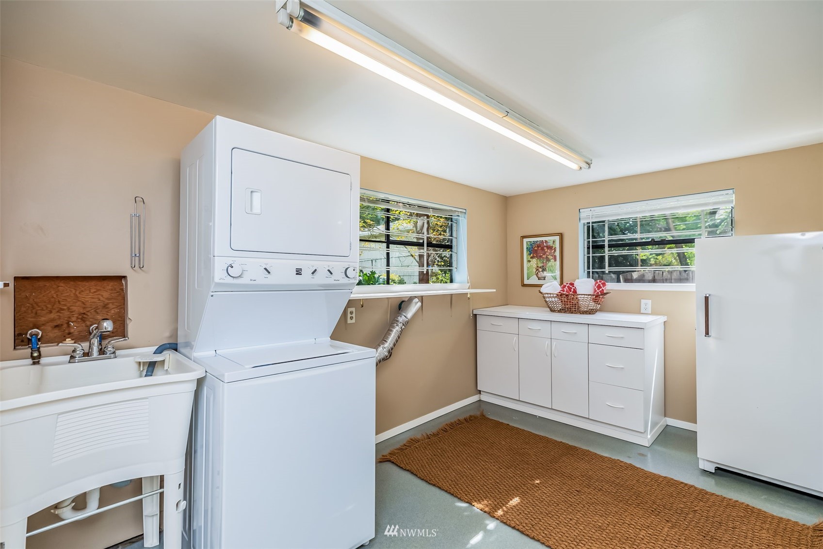 8402 13th Avenue Southwest Seattle, WA 98106 - Photo 28 of 40 a room with a washer dryer and white cabinets