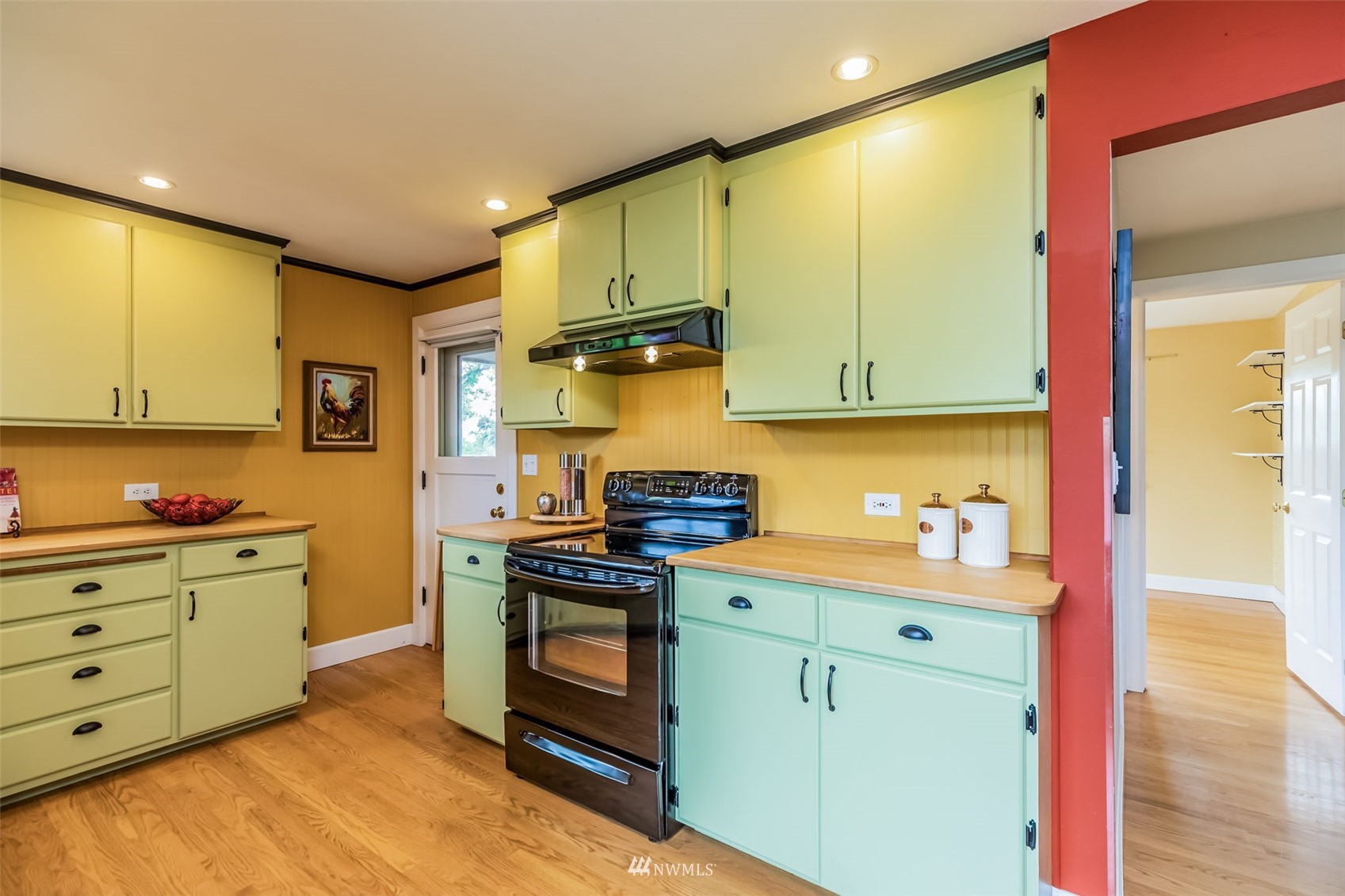 8402 13th Avenue Southwest Seattle, WA 98106 - Photo 9 of 40 a kitchen with stainless steel appliances a stove a sink cabinets and a wooden floor