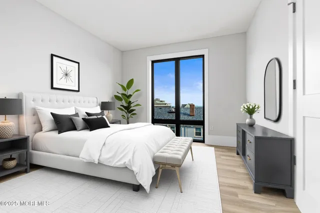 a bedroom with bed a table and potted plant