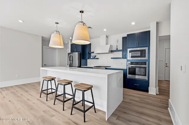 a kitchen with kitchen island a stove a sink and a refrigerator