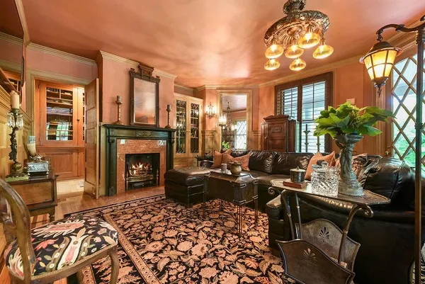 a living room with furniture a fireplace and a chandelier