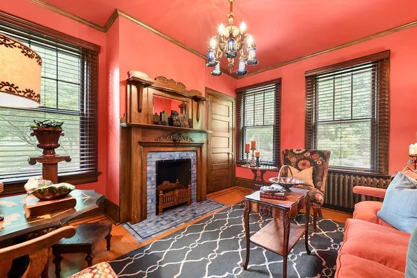 a living room with fireplace furniture and a large window