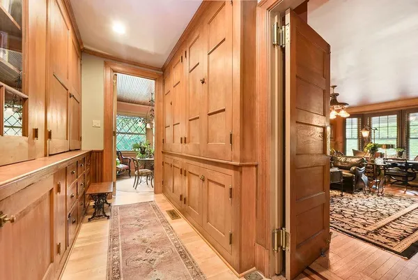 a view of a hallway with wooden floor and furniture