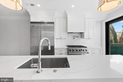 a kitchen with stainless steel appliances granite countertop a stove a refrigerator and a cabinets