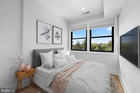 a spacious bedroom with a bed and a large window