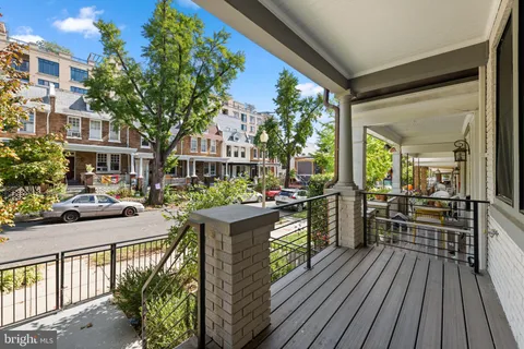 a view of a patio with couches potted plants and wooden floor