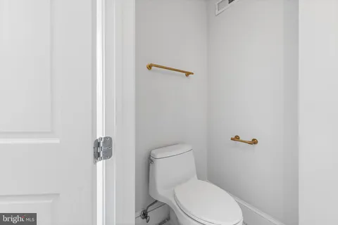 a white toilet sitting next to a shower