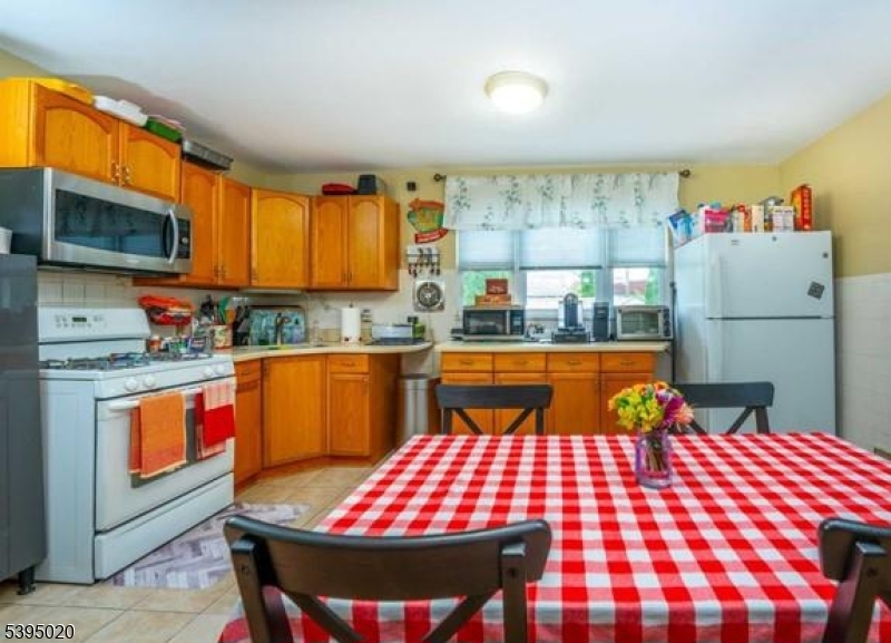 220 North 17th Street Bloomfield, NJ 07003 - Photo 3 of 19 a room with stainless steel appliances kitchen island granite countertop dining table chairs cabinets and a window