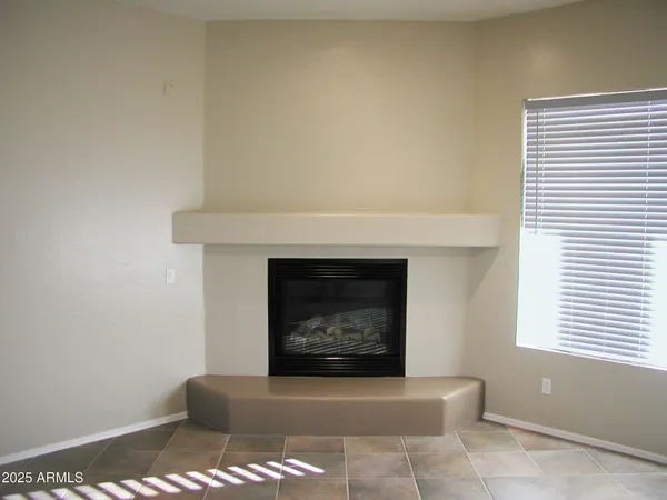 an empty room with a window and a fan
