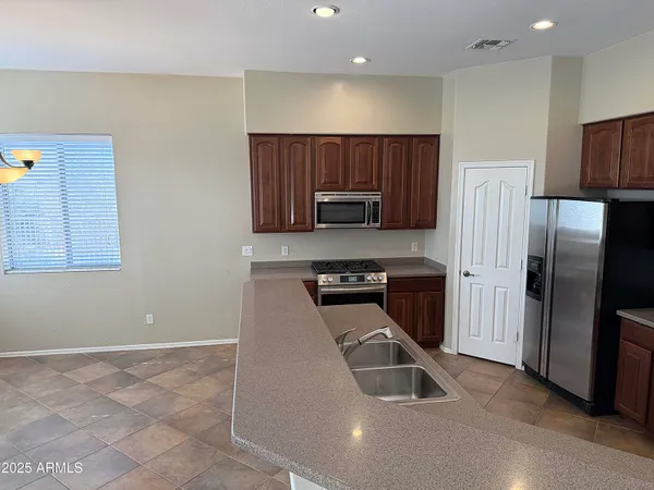a large kitchen with a stove a refrigerator and a sink
