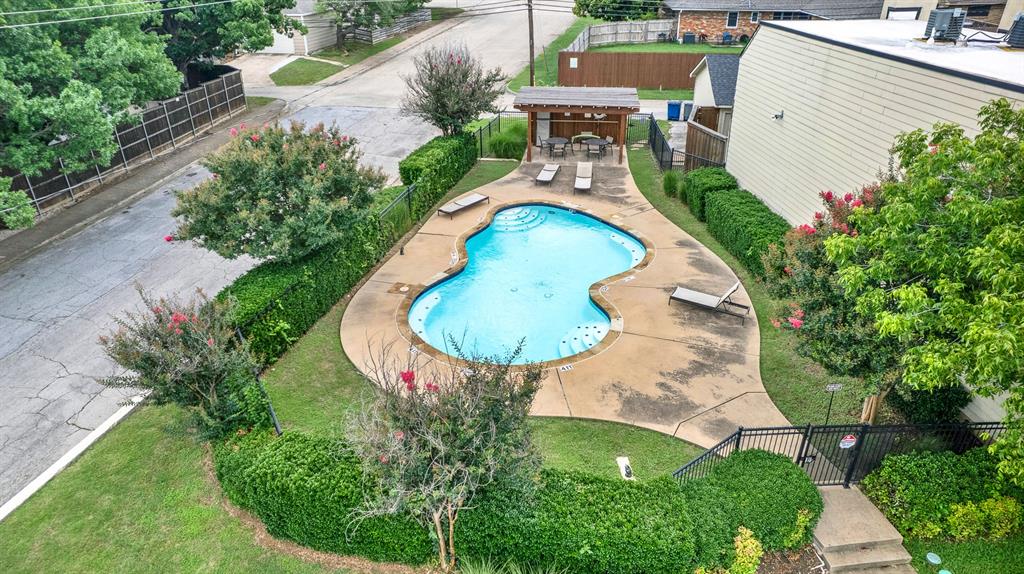 9471 Timberleaf Drive Dallas, TX 75243 - Photo 35 of 39 Freeform swimming pool with surrounding concrete decking, complemented by a covered outdoor seating area