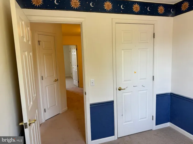a view of an empty room with closet and a bathroom