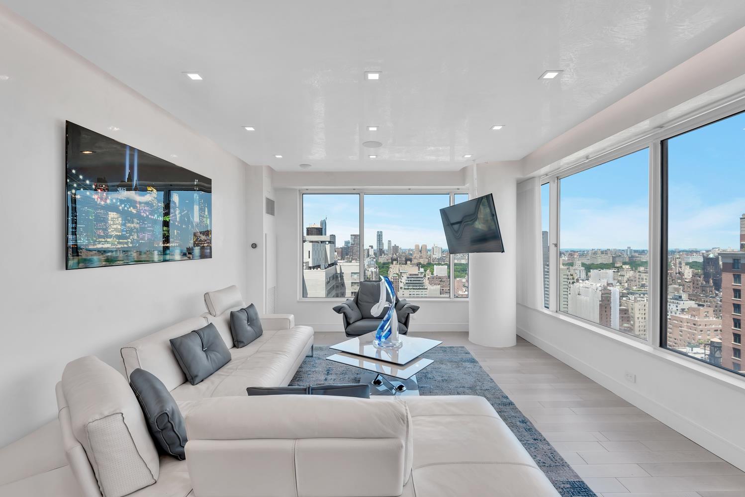 200 East 69th Street, Unit 31A Manhattan, NY 10021 - Photo 2 of 19 a living room with furniture large window and flat screen tv