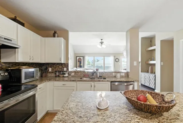 a kitchen with a sink stove and white cabinets