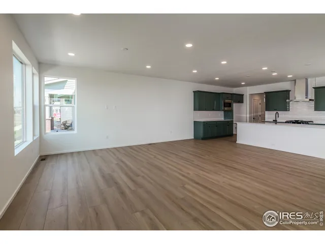 a view of empty room with kitchen and window