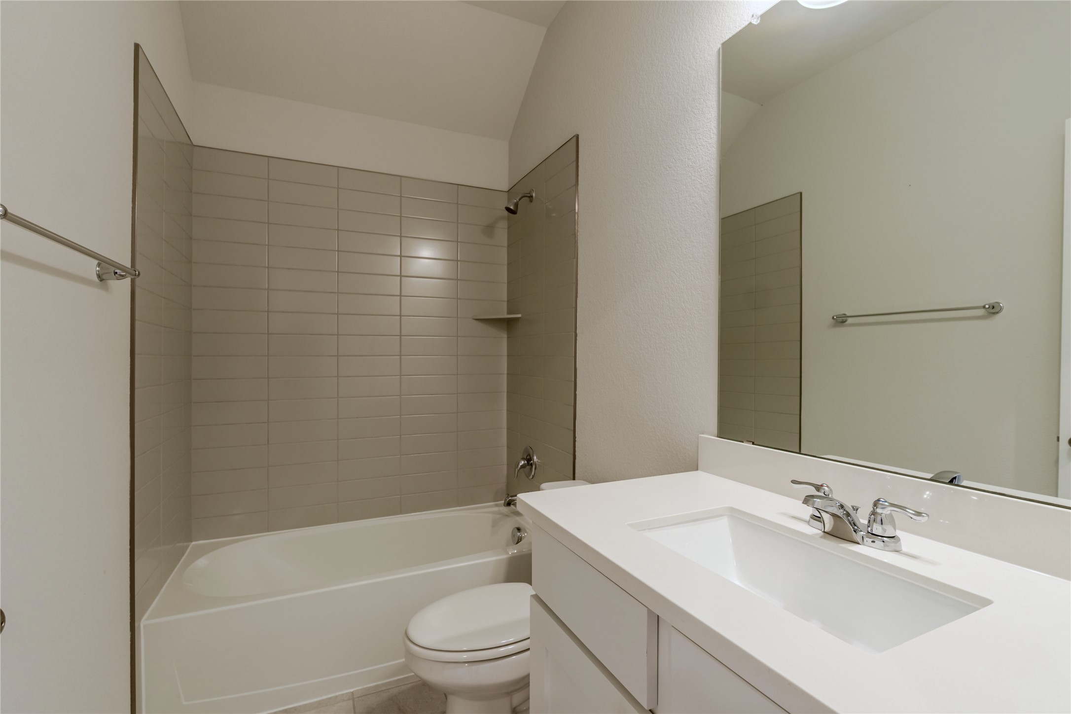 1117 Terrace View Georgetown, TX 78628 - Photo 22 of 25 Bathroom featuring a built-in tub with light-toned horizontal tile surround, a single vanity with an integrated white sink, a chrome faucet, and a large wall-mounted mirror