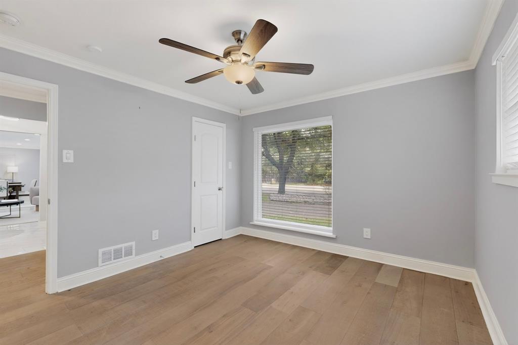 7631 Meadow Road Dallas, TX 75230 - Photo 23 of 40 A bright bedroom with a ceiling fan, a tall, wide window and a closet