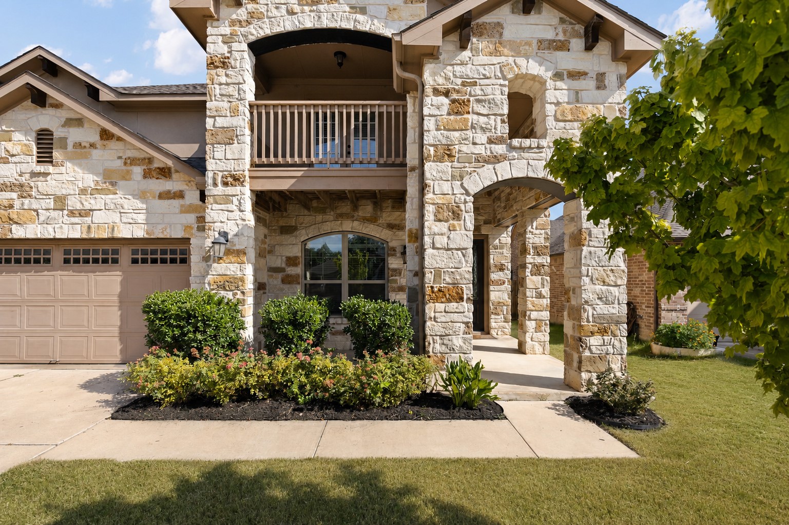 2400 Leonards Pass Leander, TX 78641 - Photo 3 of 40 A striking stone facade with arched entryways and a second-story balcony offers a grand welcome.