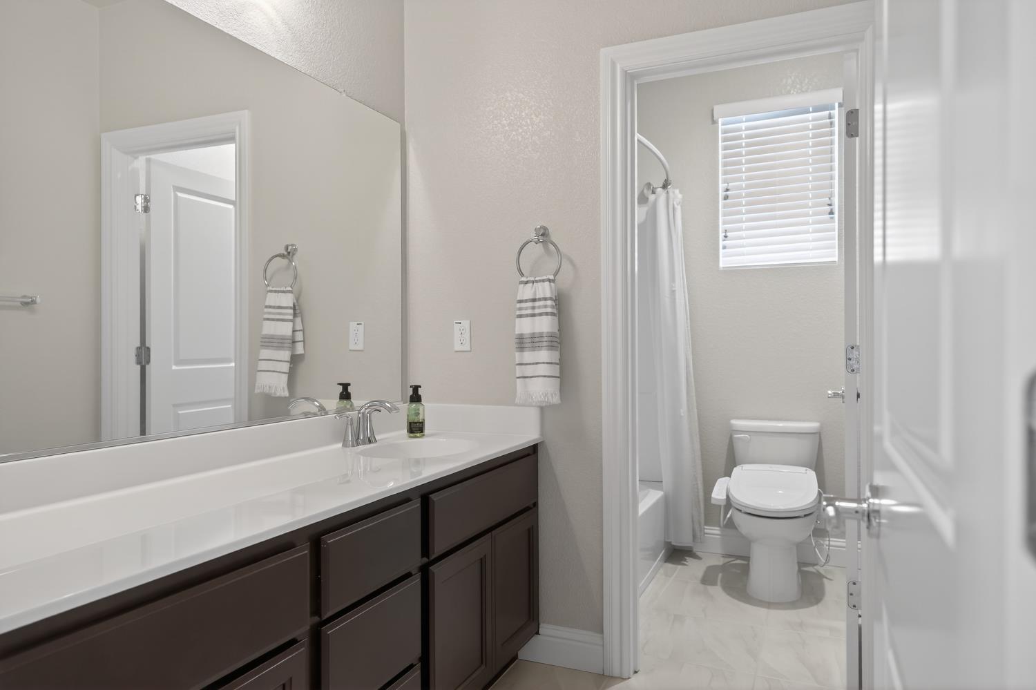 183 Michael Cox Lane Tracy, CA 95377 - Photo 28 of 35 a bathroom with a sink toilet and a mirror