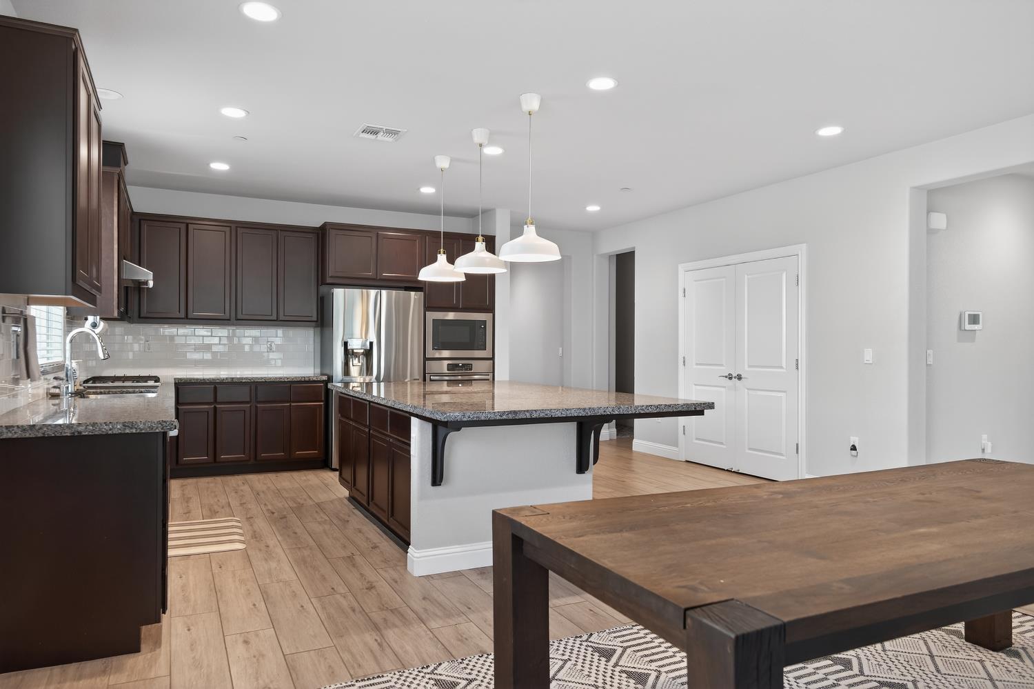 183 Michael Cox Lane Tracy, CA 95377 - Photo 10 of 35 a kitchen with stainless steel appliances kitchen island granite countertop a stove a sink and a refrigerator