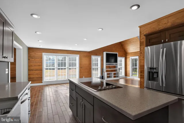 a kitchen with stainless steel appliances granite countertop a sink a stove and a refrigerator