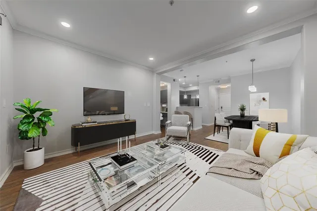 a living room with furniture a flat screen tv and a potted plant